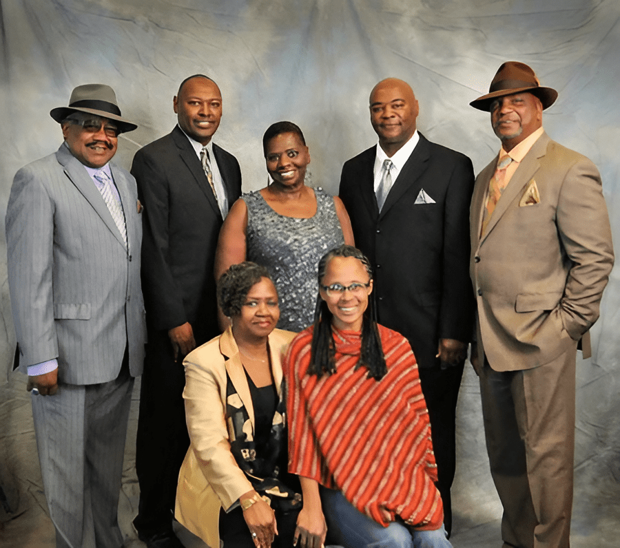 A group of people in suits and hats posing for the camera.